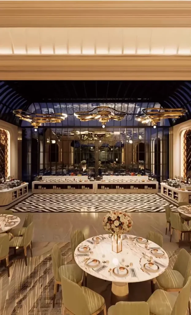 A dining table laid with florals and gold-rimmed crockery beneath a glass roof